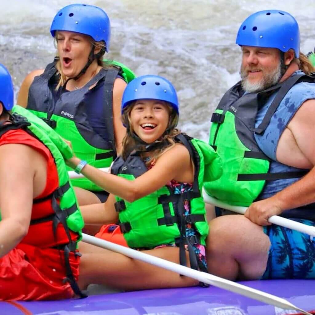 Rafters in life vests paddling on a river.